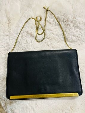Chic black leather shoulder bag with slinky gold chain